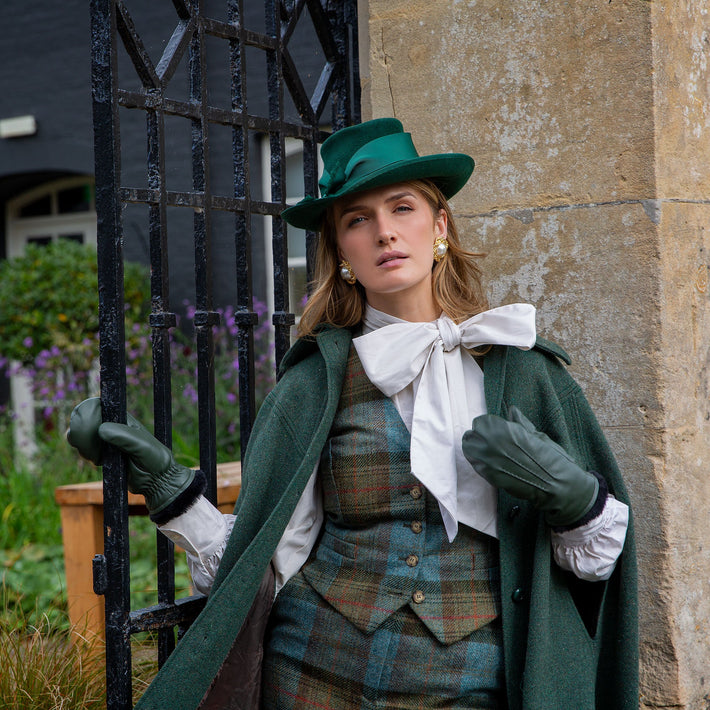 Woman wearing faux fur-lined leather mittens with three-point outside at an estate.