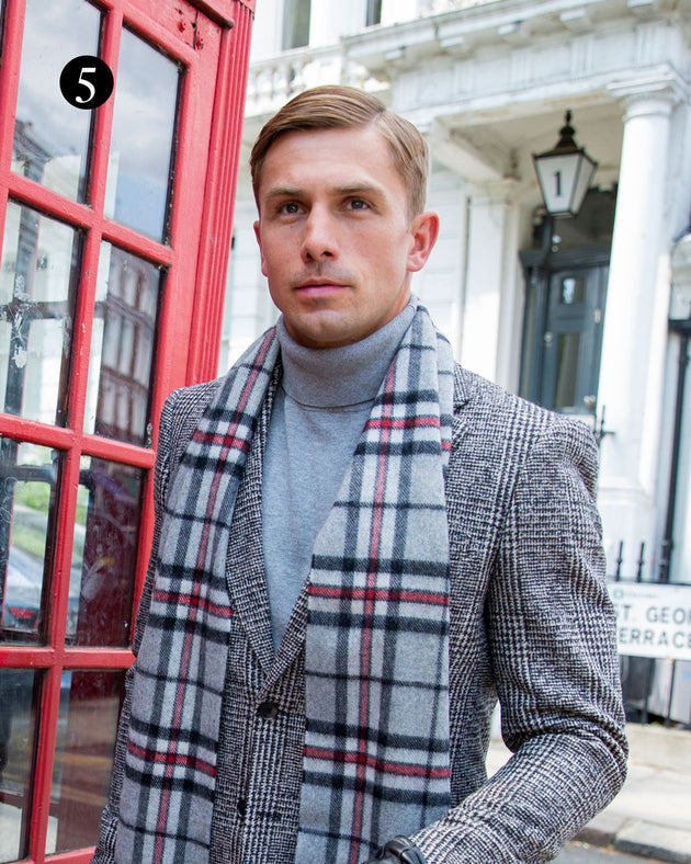 Man wearing check cashmere scarf in silver walking past a red telephone booth