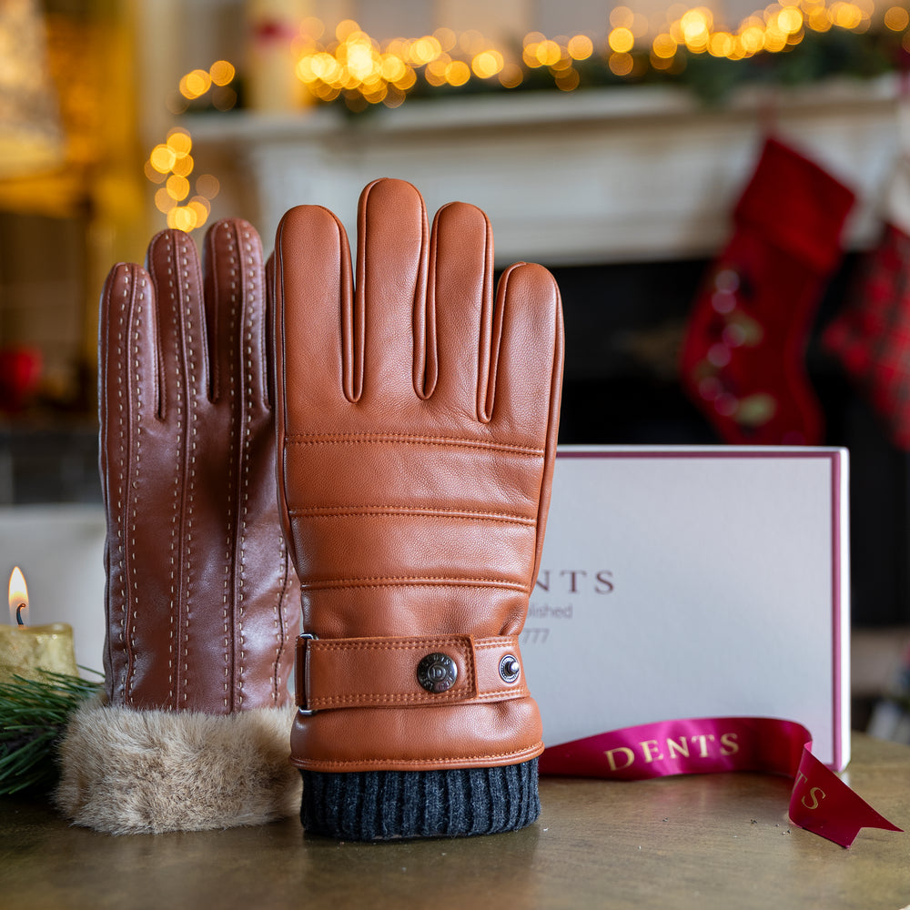 en's and women's brown leather gloves on a table with a festive background