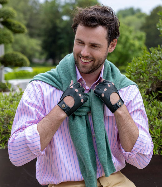 Man wearing leather fingerless driving gloves in green outside