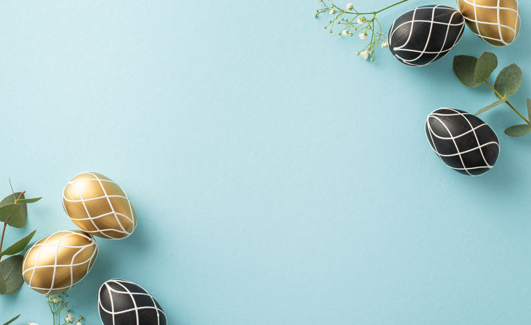 blue background with black and gold easter eggs with white flowers.