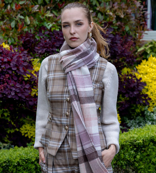 Woman wearing cashmere check scarf in pink outdoors