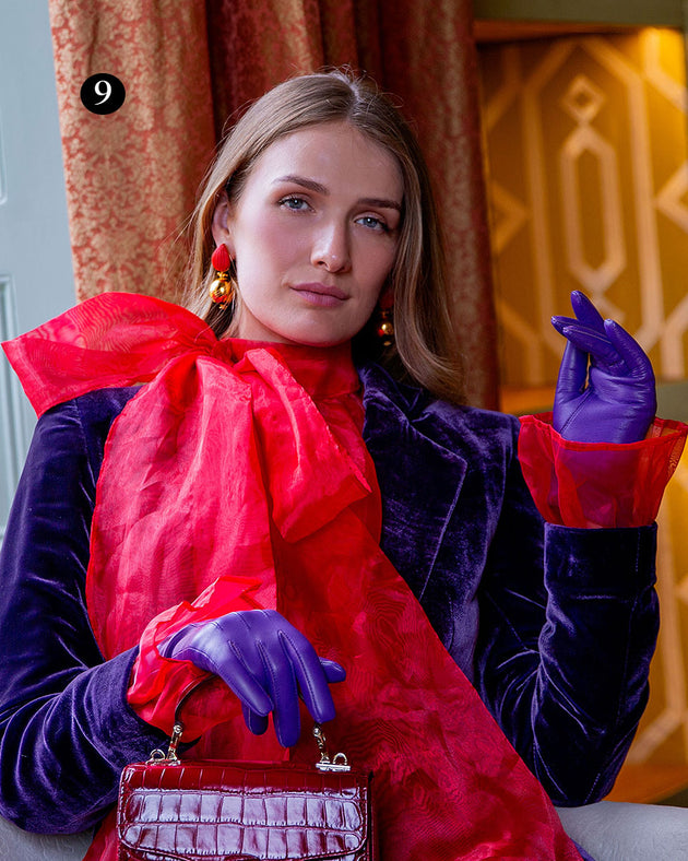 Woman wearing three point lined leather gloves in amethyst