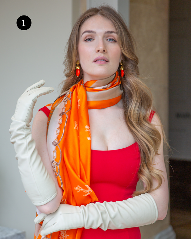 Woman wearing single-point long above-elbow leather gloves in ivory in red dress. 