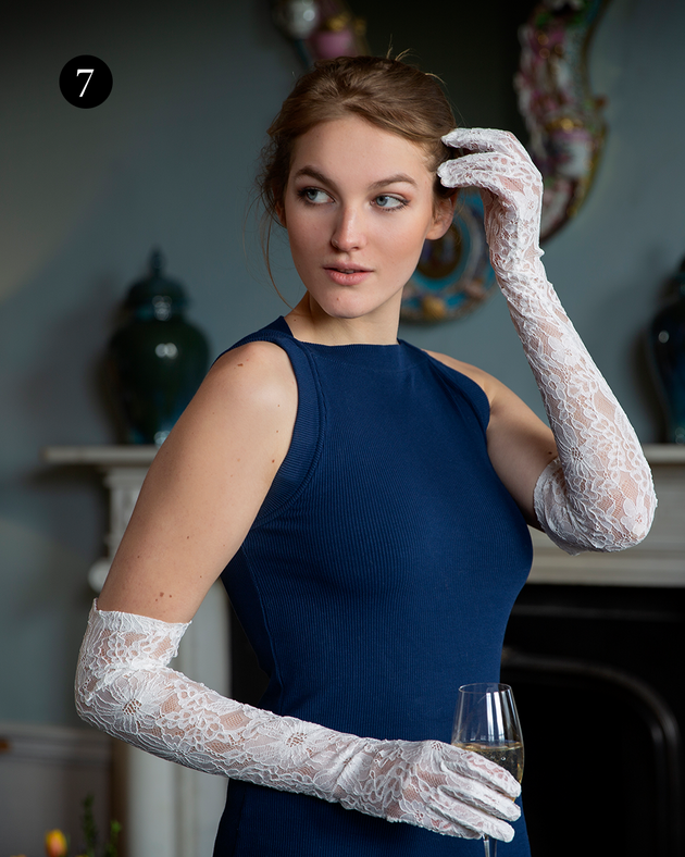 Woman wearing long opera lace gloves in ivory with blue dress indoors event.
